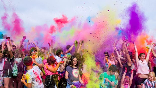 pexels-photo-1684187-1684187 A joyful crowd covered in vivid colors celebrates a festival outdoors with flying powder.